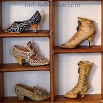 Miniature women's antique shoes in a shadow box
